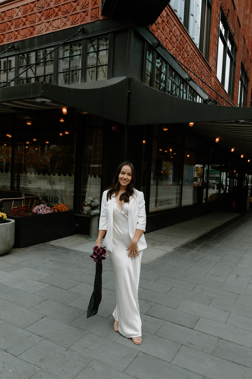 Bride wearing the Amore Ivory Bridal Dress Styled with a white blazer and heels
