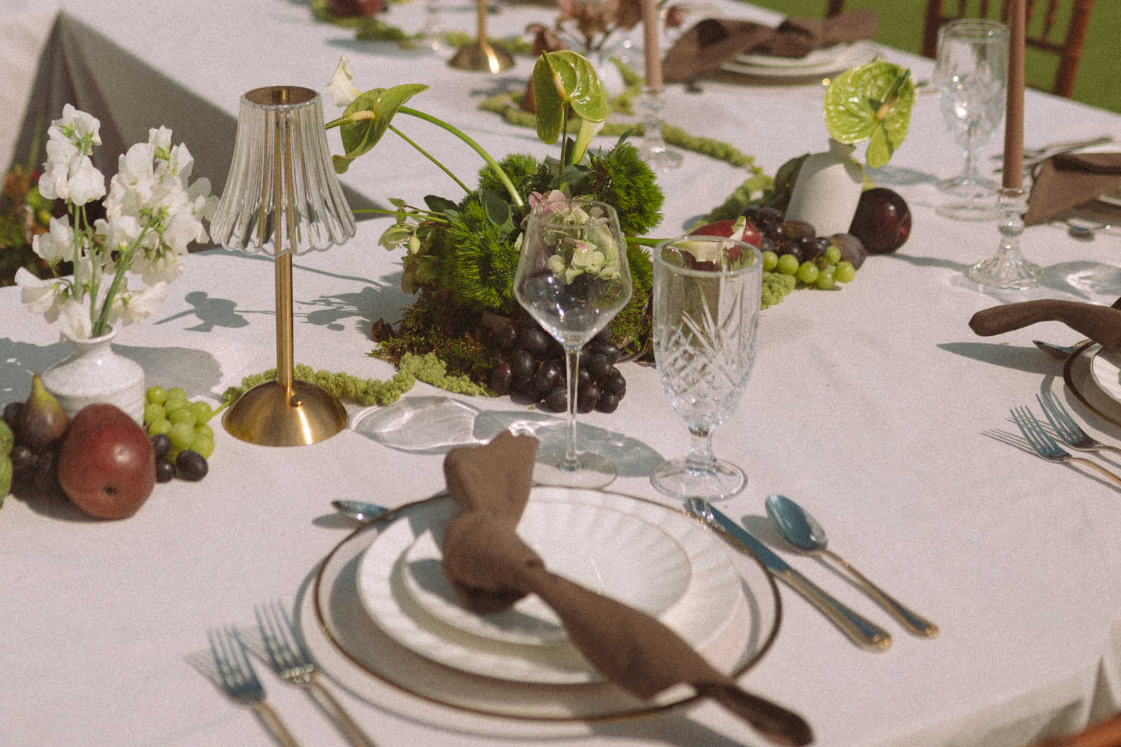 Gorgeous table setting for a wedding with flowers, fruits, and timeless silverware