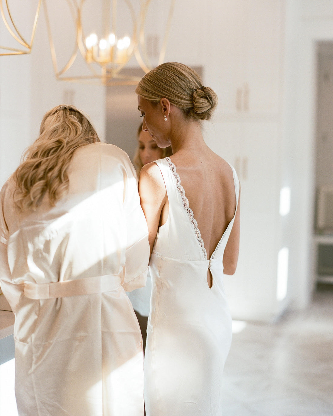 Bride getting ready in an ivory bridal slip dress with lace details